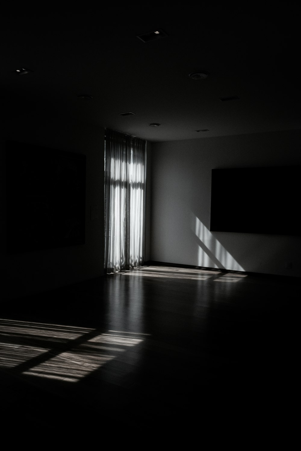 a dark room with light coming through the windows