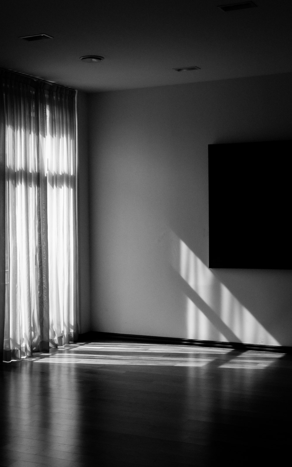 Una foto in bianco e nero di una stanza con una grande finestra