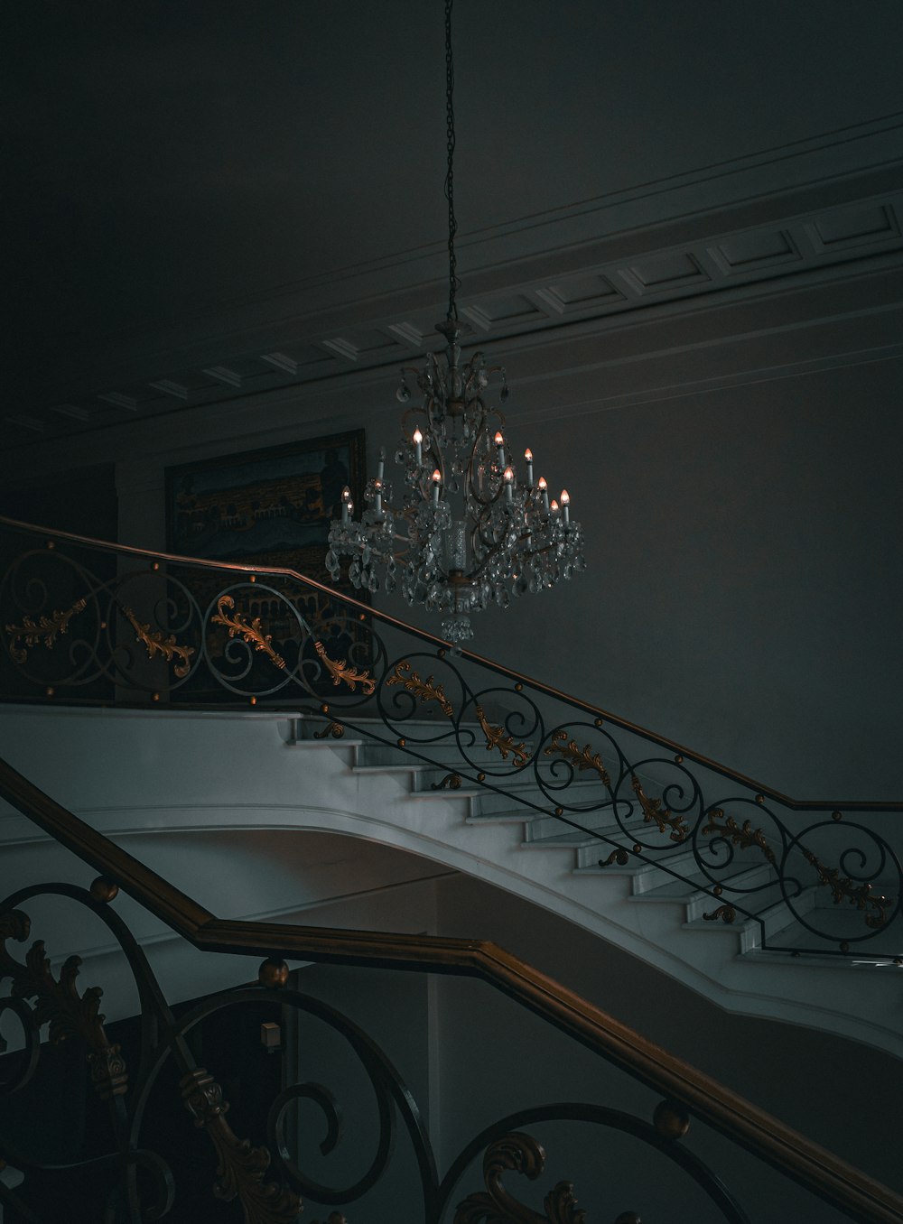 a chandelier hanging from the ceiling next to a set of stairs