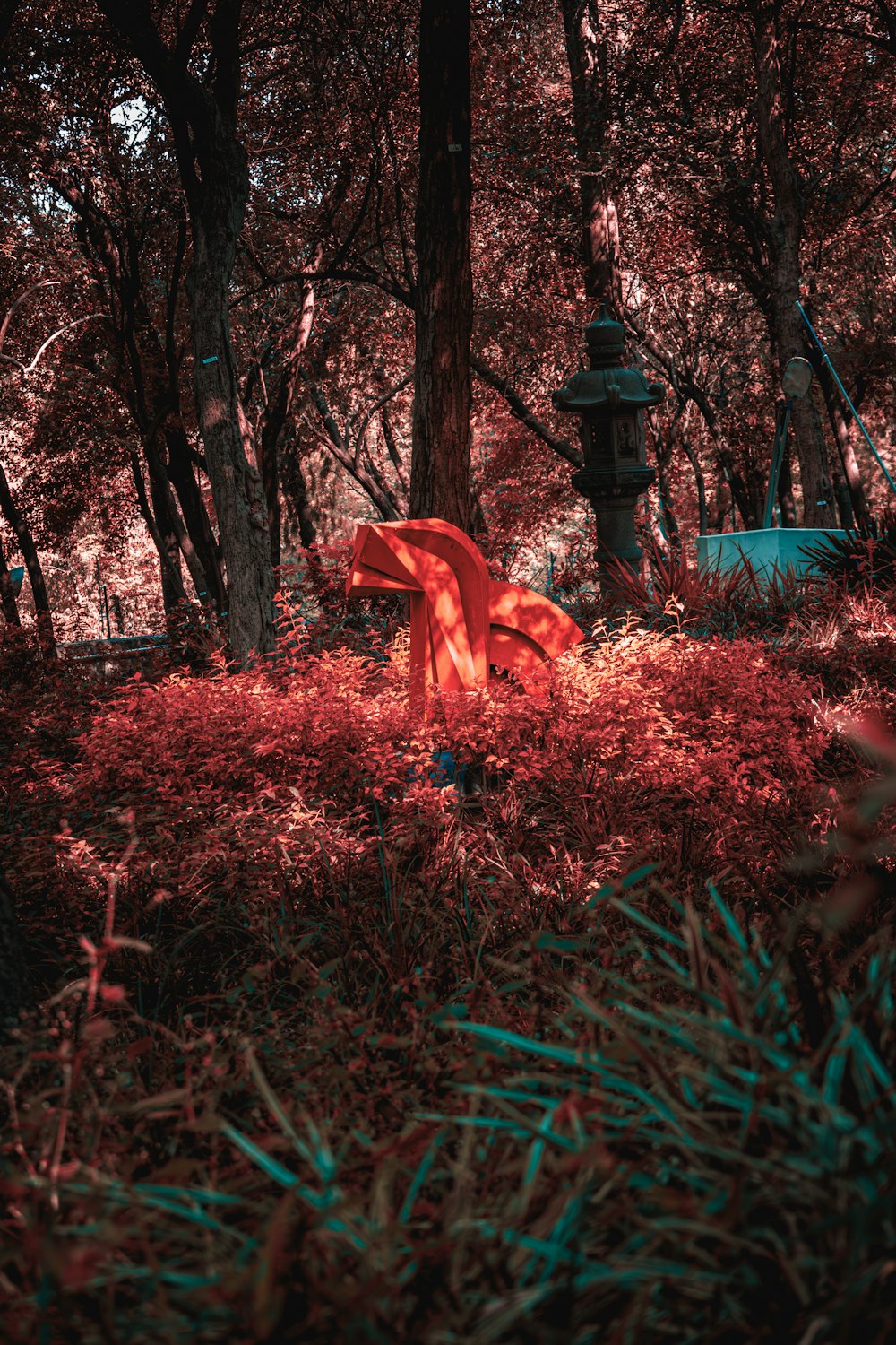 a red object in the middle of a forest