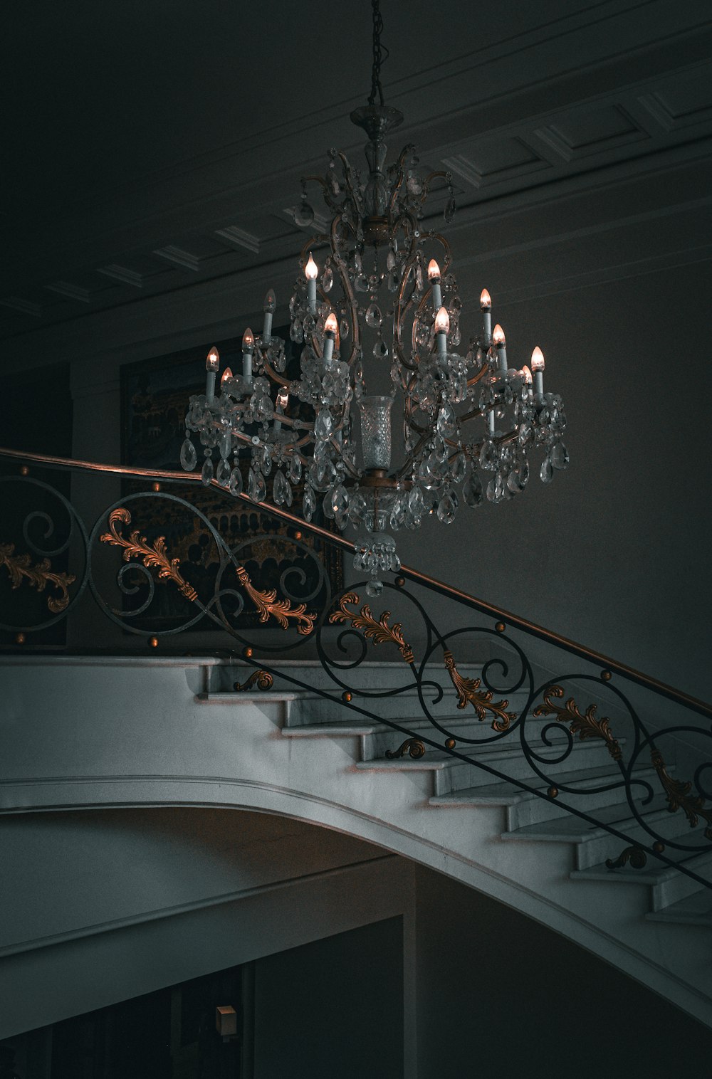 a chandelier hanging from the side of a stair case