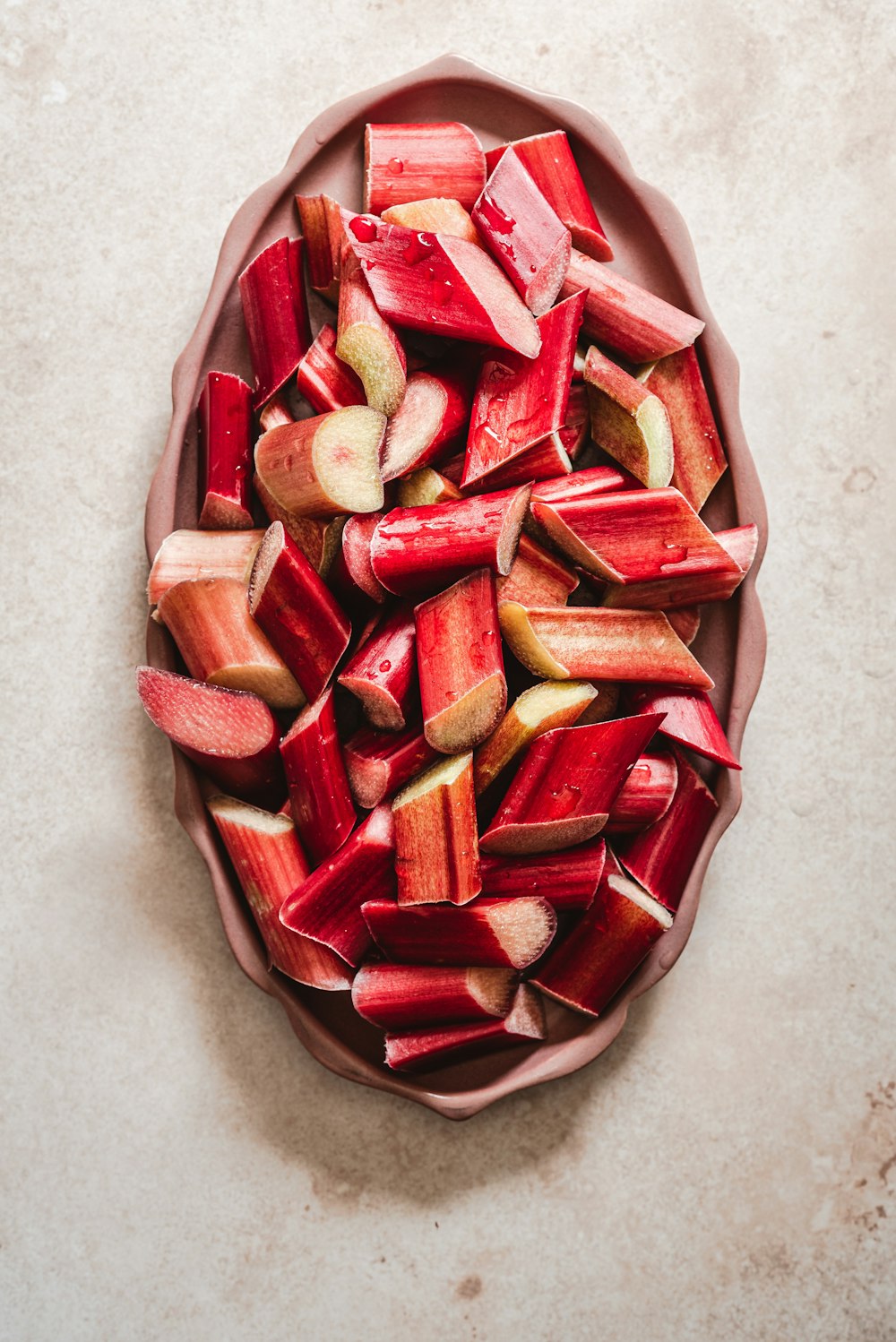 a bowl filled with sliced up rhubaras on top of a table