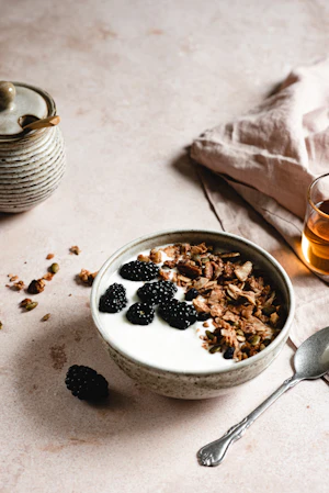 Bowl of greek yogurt topped with granola and fresh fruit