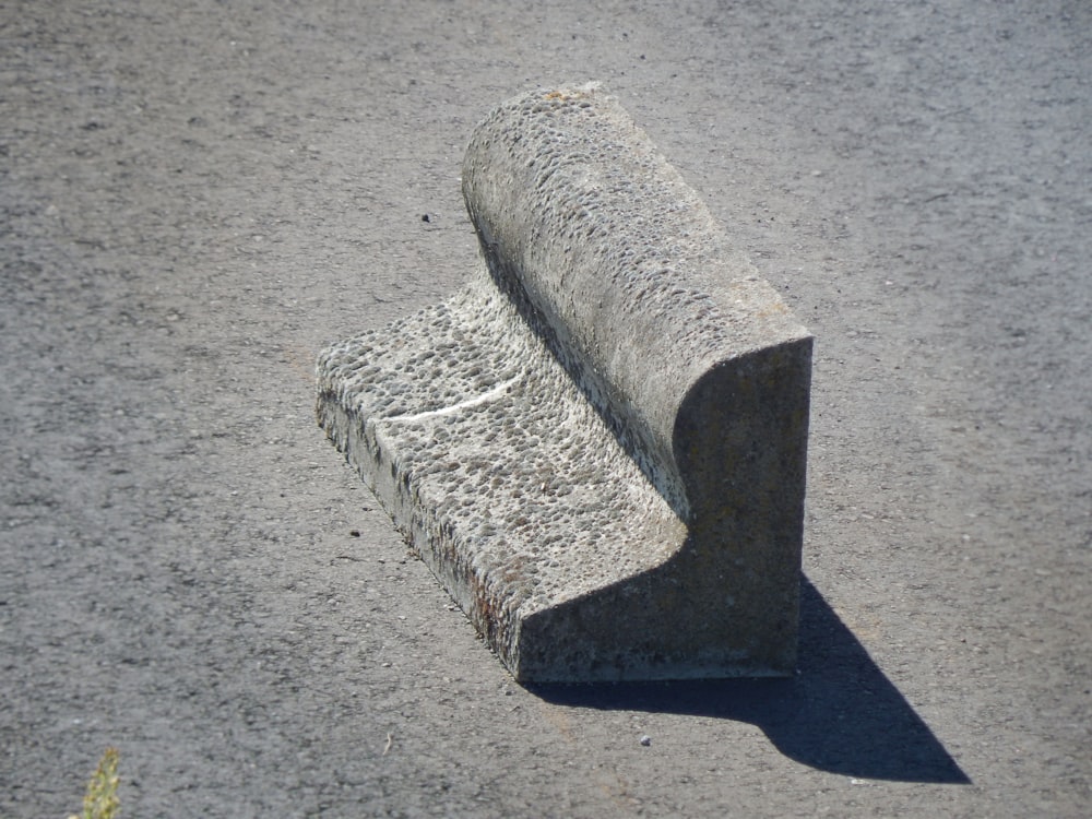 una panchina di cemento seduta sul ciglio di una strada