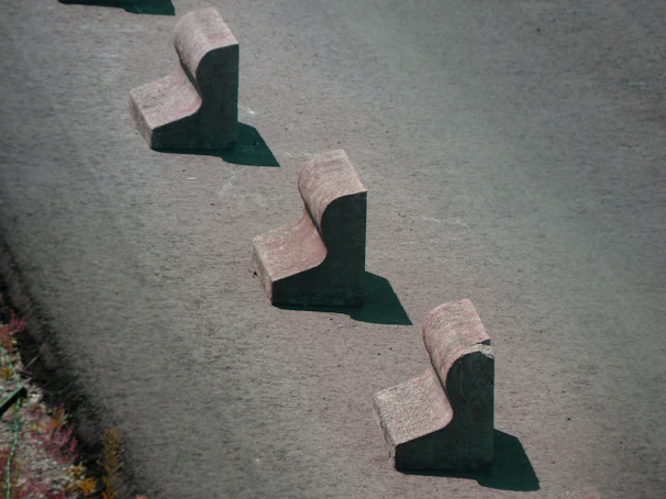 Steelguard barriers with flat feet arranged along a busy road for public safety and crowd control.