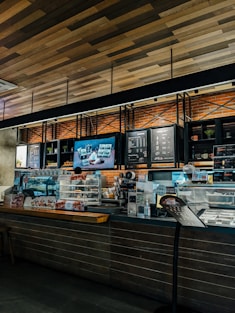 A cozy coffee shop interior with a variety of coffee drinks displayed on a wooden counter.