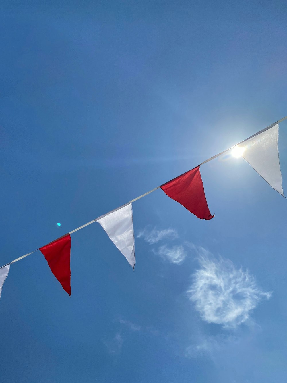 three red and white flags flying in the sky