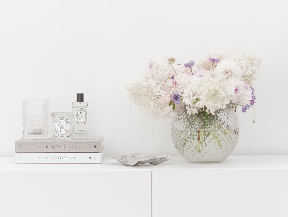 a vase of flowers sitting on top of a white shelf