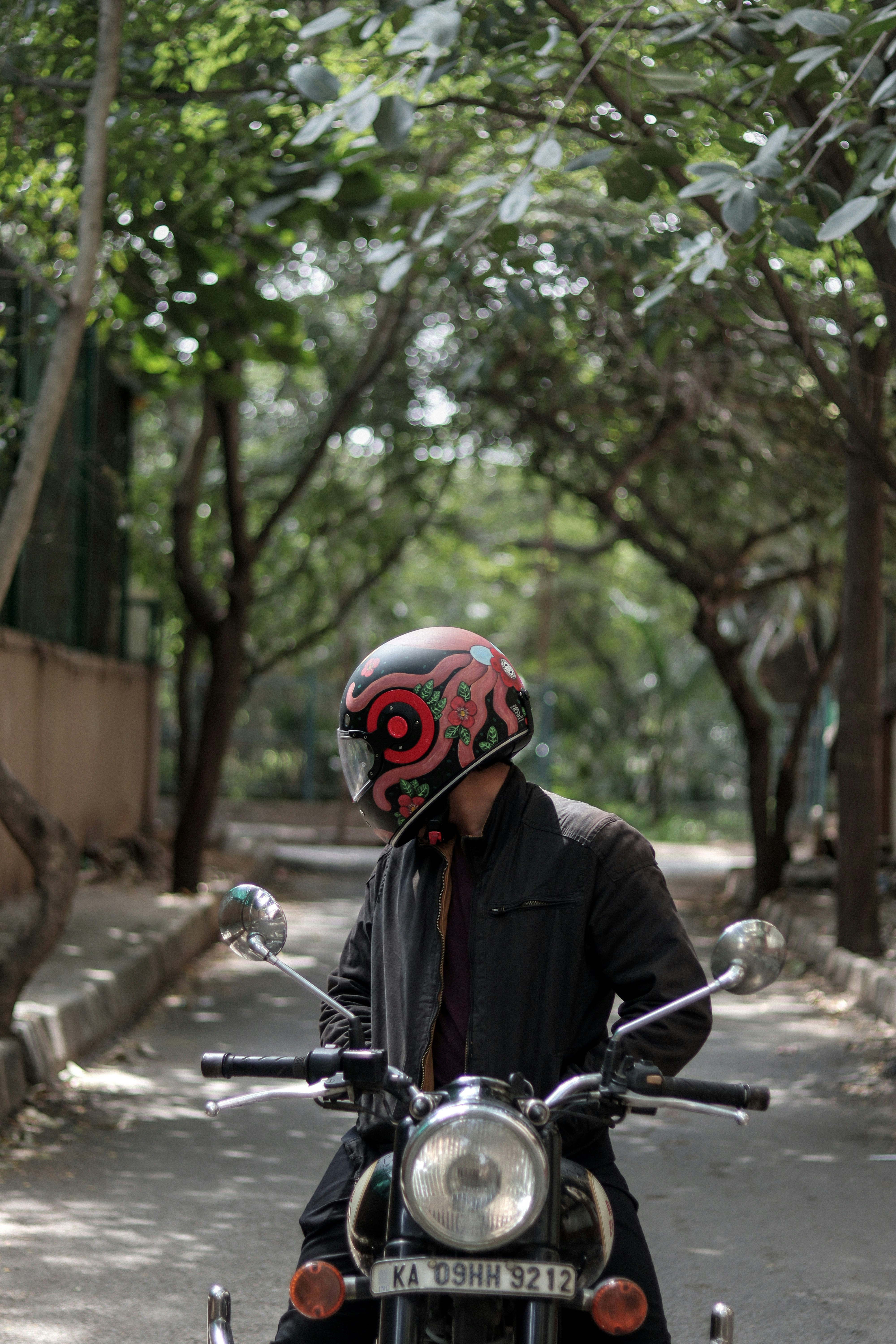 Rider in a custom helmet sits on a classic motorcycle.