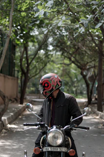 A rider wearing a Lumina helmet cruising past vibrant urban street art on a sunny day.