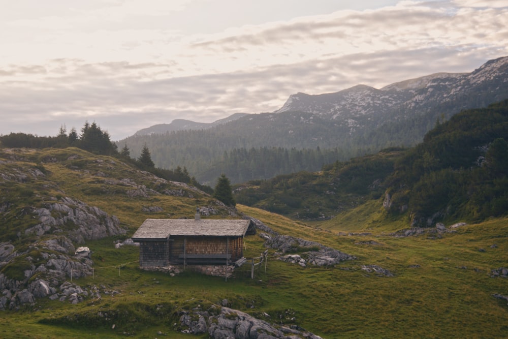 a small cabin in the middle of a grassy field