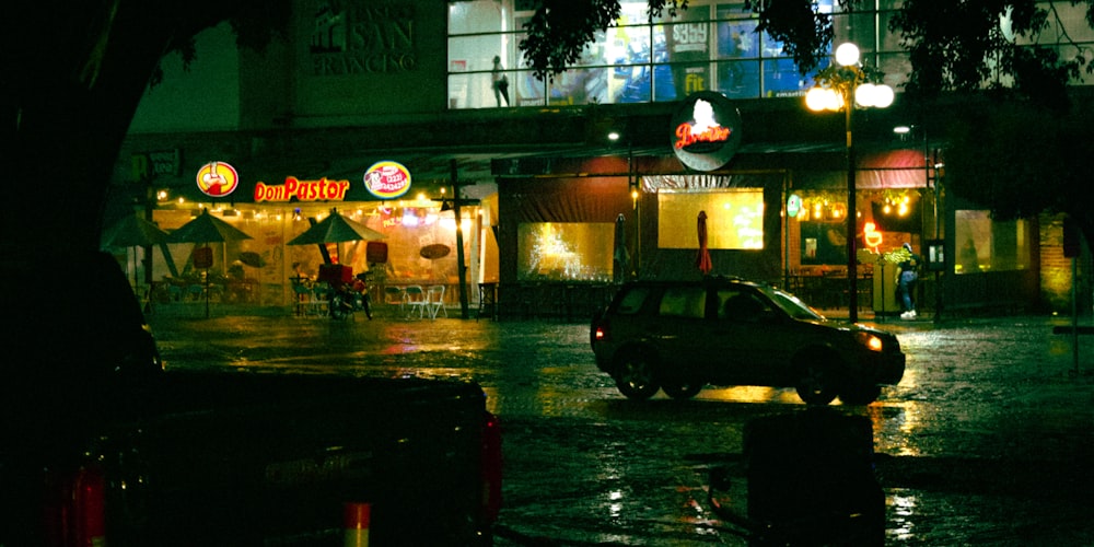 a car driving down a wet street at night