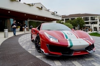 A sleek, clean rental car ready parked in front of a hotel entrance.