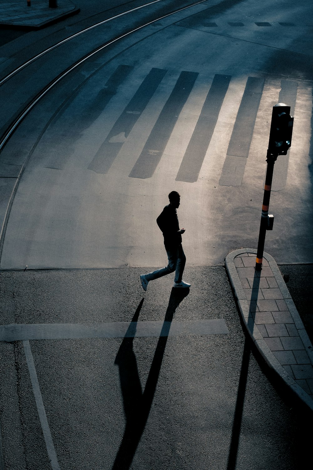 a man running down a street next to a traffic light