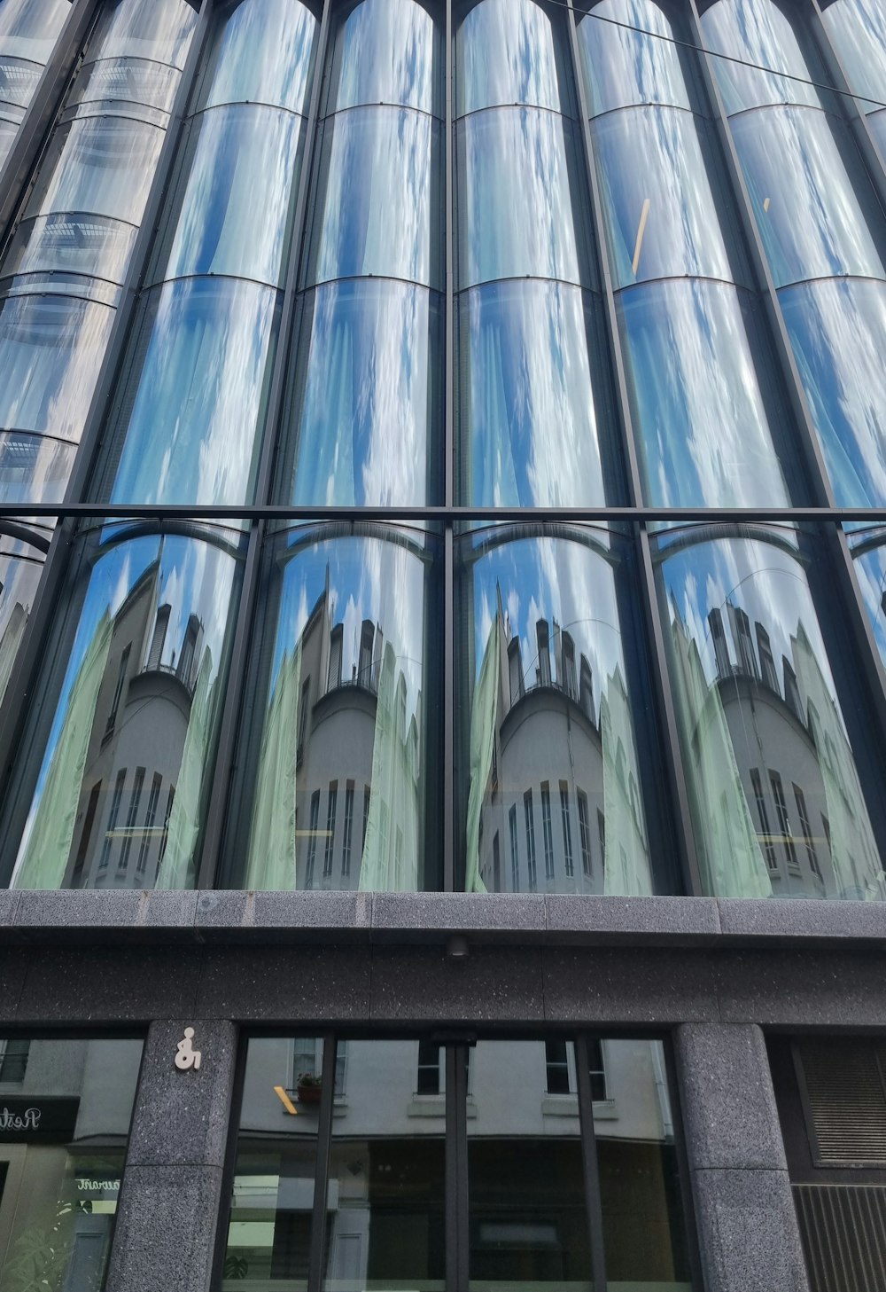 a tall building with many windows reflecting the sky