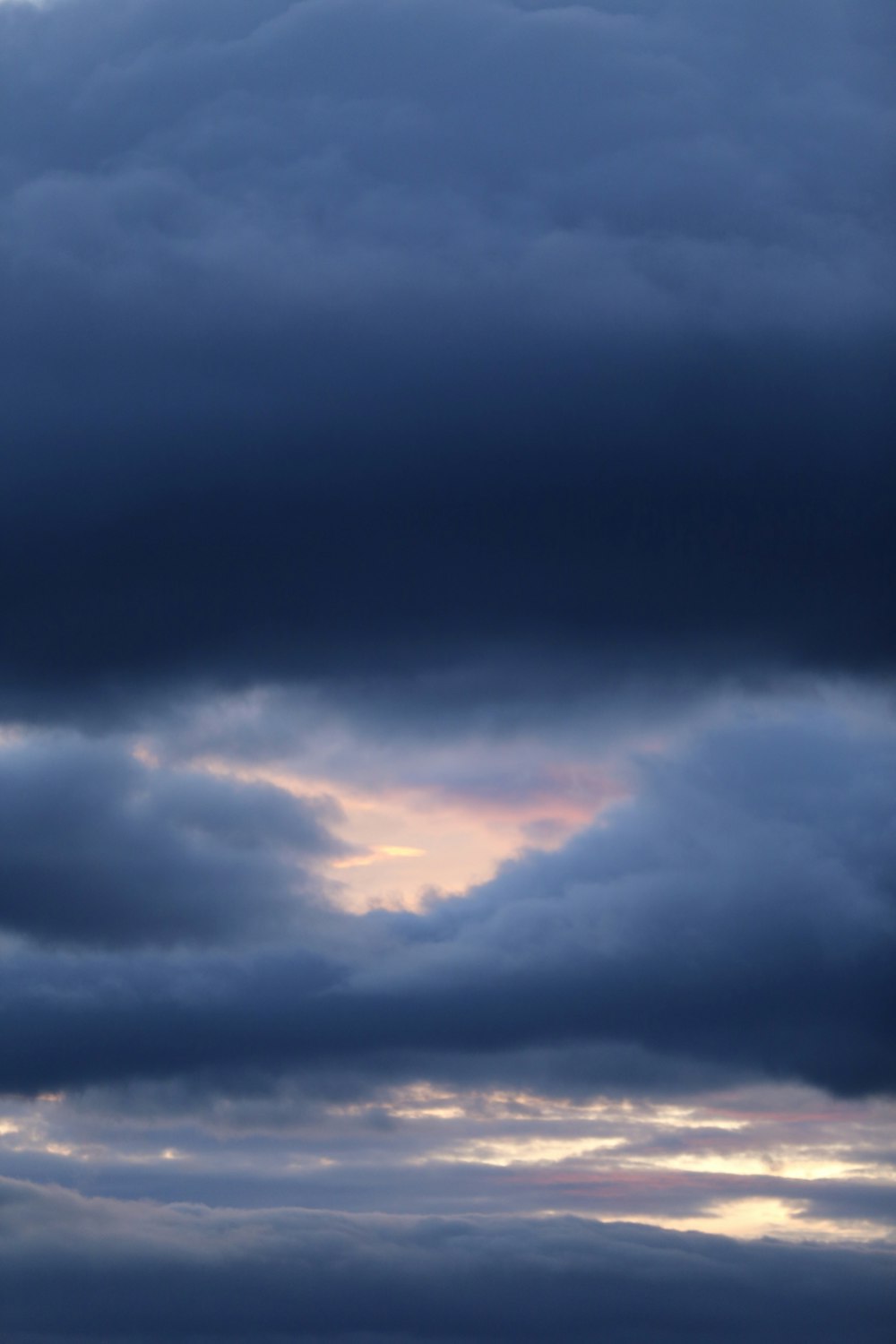 a plane flying through a cloudy sky at sunset