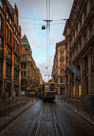 a train traveling down a street next to tall buildings
