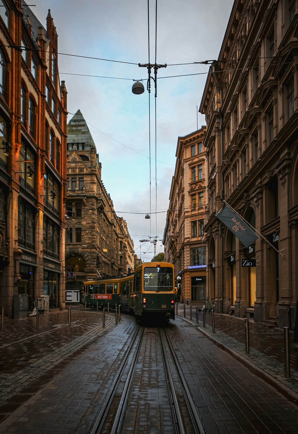 a train traveling down a street next to tall buildings