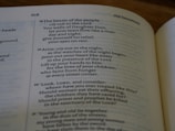 An open book displaying a passage from the Old Testament with text that discusses prayer, grief, and lamentation. The book is laid flat, and the focus is on the content, highlighting verses with emotional and religious themes.