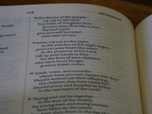 An open book displaying a passage from the Old Testament with text that discusses prayer, grief, and lamentation. The book is laid flat, and the focus is on the content, highlighting verses with emotional and religious themes.