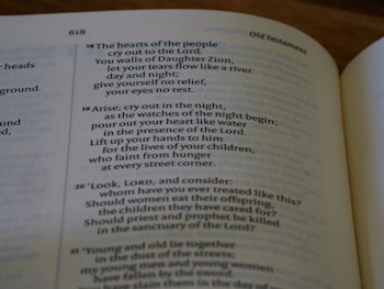 An open book displaying a passage from the Old Testament with text that discusses prayer, grief, and lamentation. The book is laid flat, and the focus is on the content, highlighting verses with emotional and religious themes.
