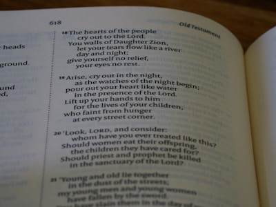 An open book displaying a passage from the Old Testament with text that discusses prayer, grief, and lamentation. The book is laid flat, and the focus is on the content, highlighting verses with emotional and religious themes.