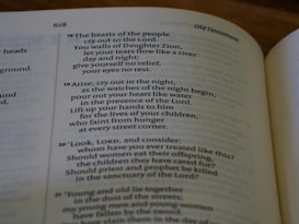 An open book displaying a passage from the Old Testament with text that discusses prayer, grief, and lamentation. The book is laid flat, and the focus is on the content, highlighting verses with emotional and religious themes.