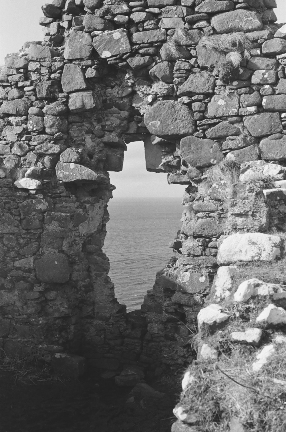 a black and white photo of a window in a stone wall