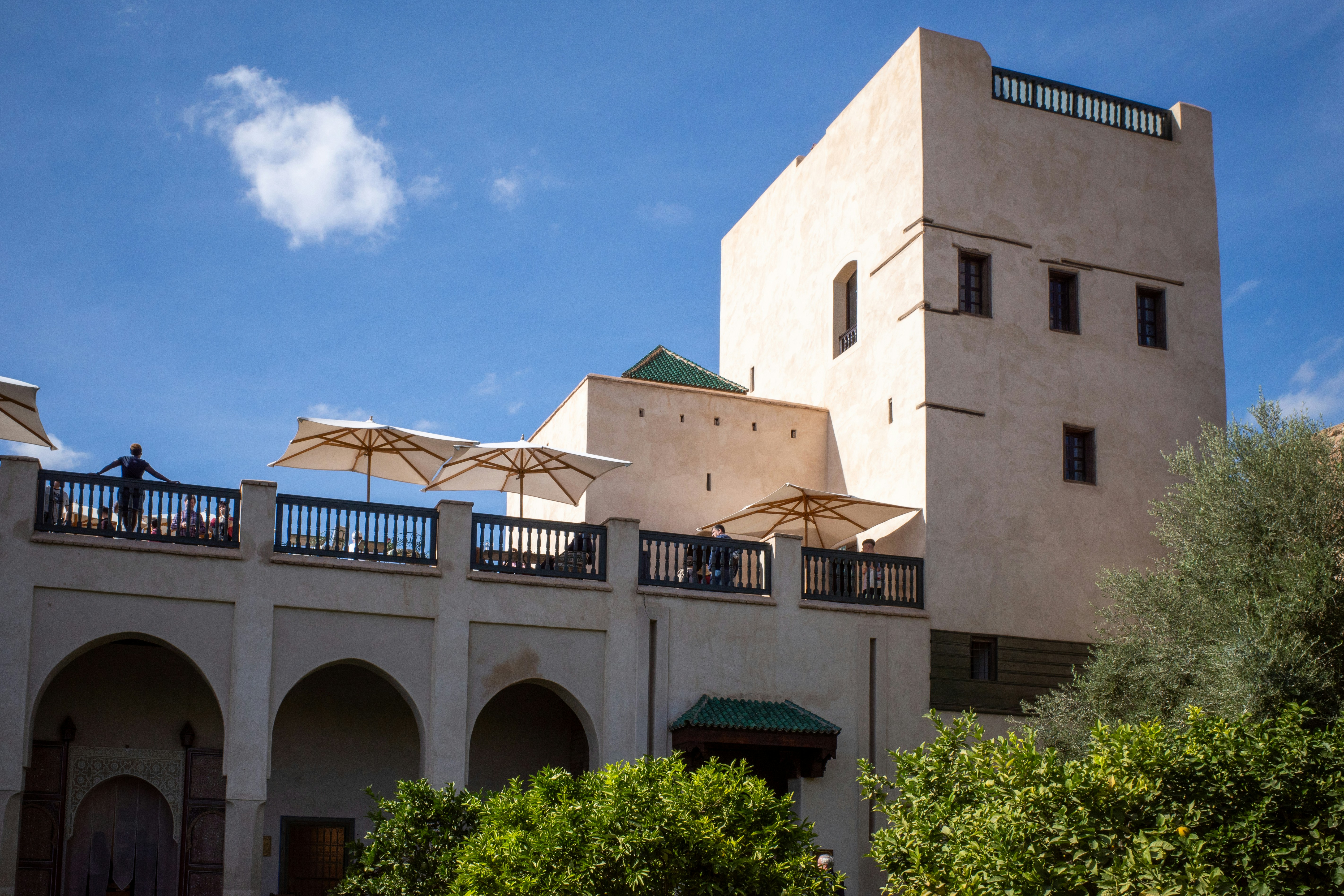 a building with a balcony and umbrellas on top of it, 