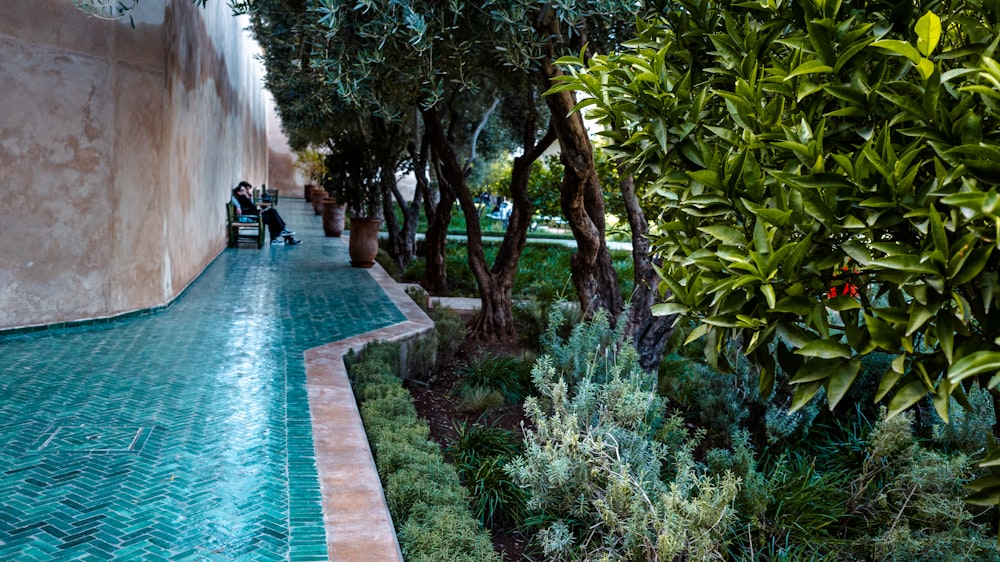 a couple of people sitting on a bench next to a pool