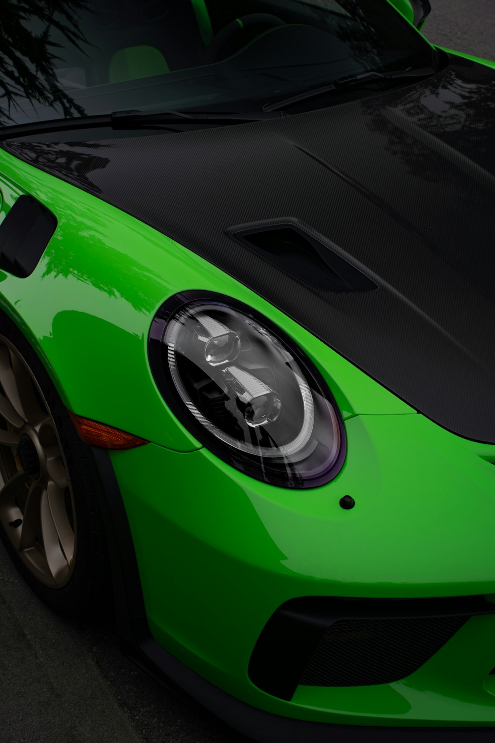 a green sports car parked on the side of the road