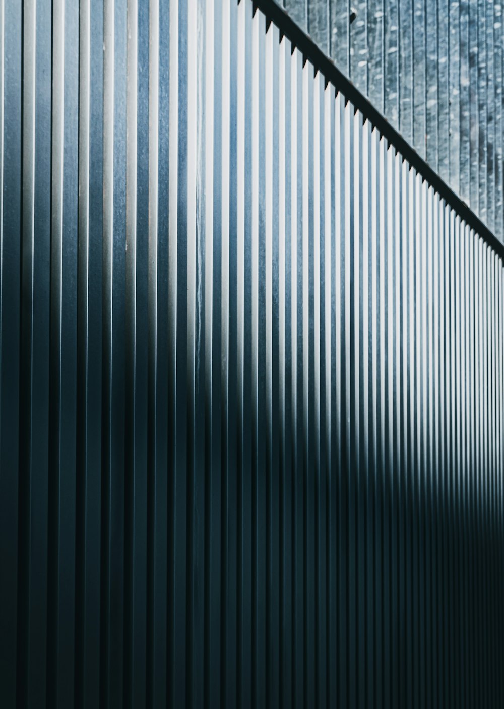 a close up of a metal fence with a sky background