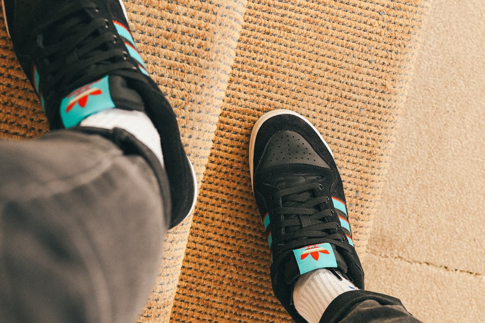 a person's feet wearing black and blue sneakers