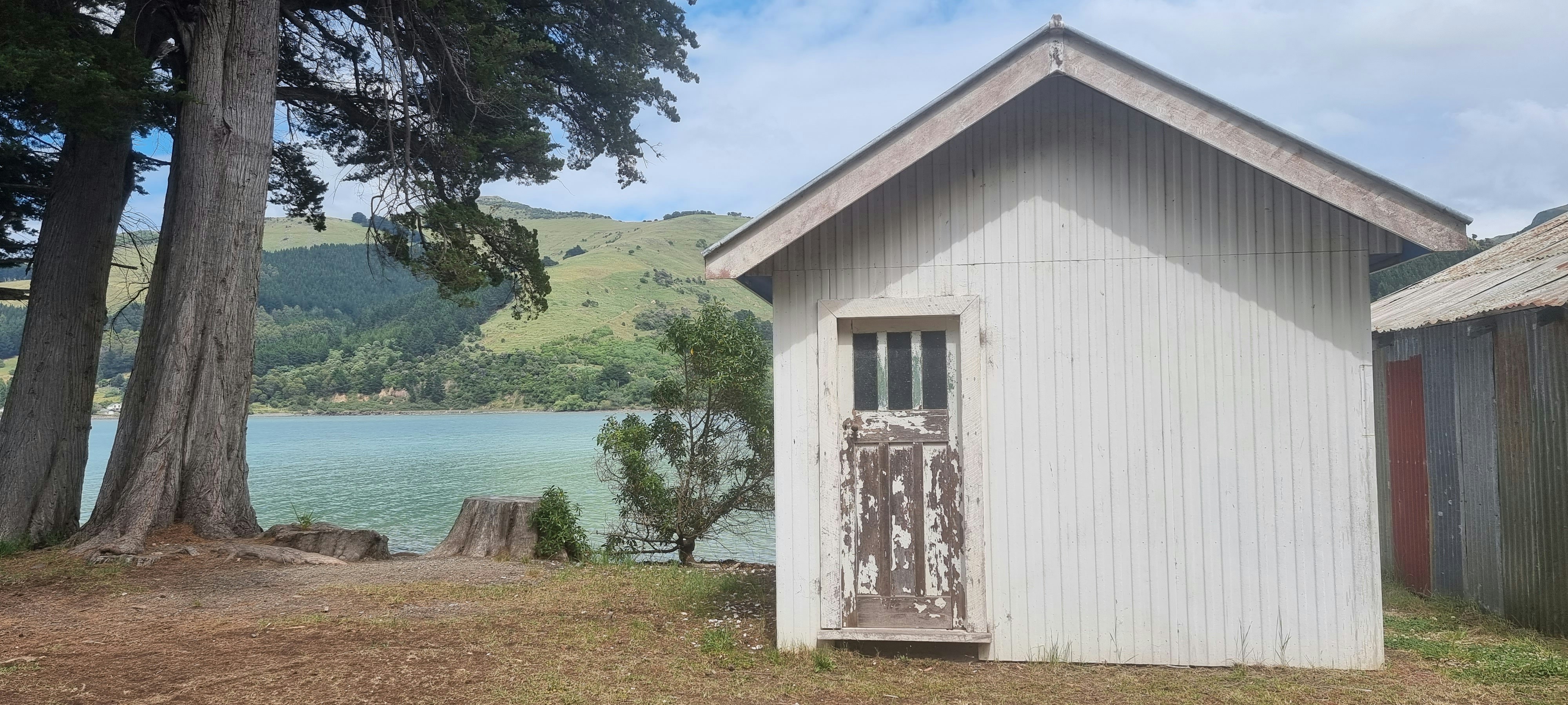 a small white building sitting next to a body of water