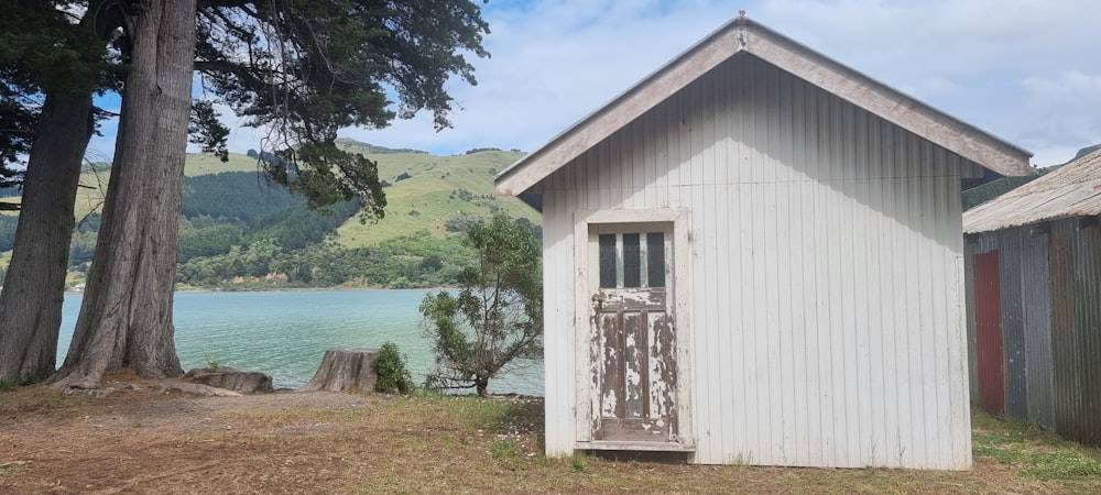 a small white building sitting next to a body of water