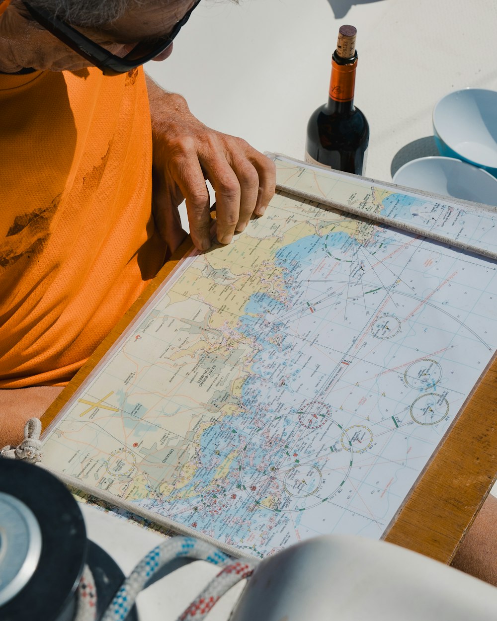 a man in an orange shirt is looking at a map