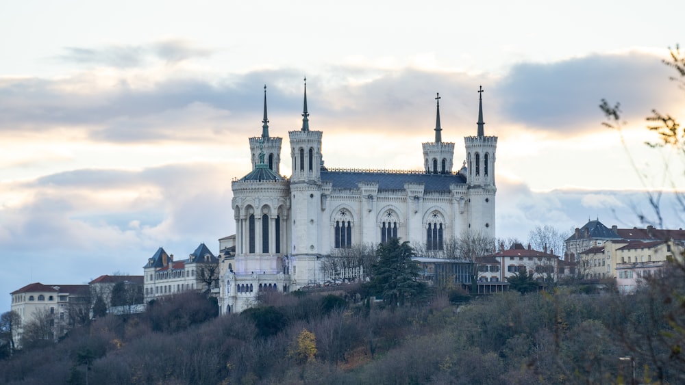 un grand bâtiment blanc au sommet d’une colline