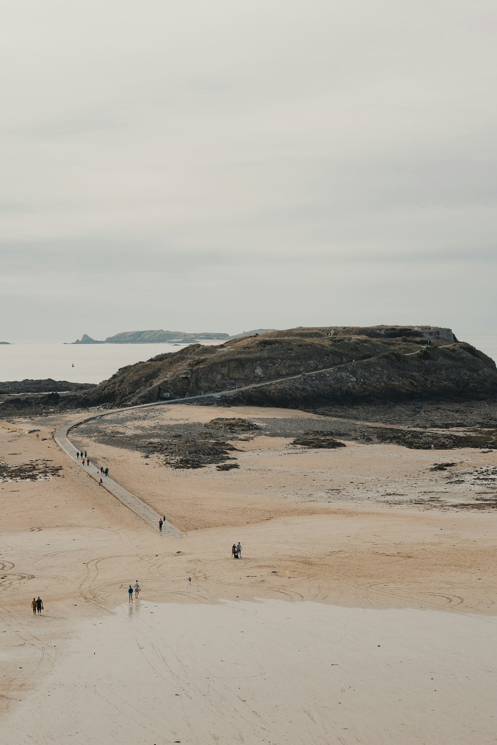 a group of people walking across a sandy beach