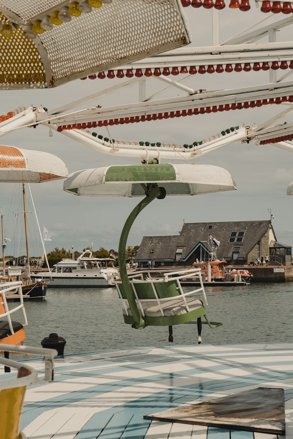 ein Haufen Stühle und Sonnenschirme, die über einem Gewässer hängen