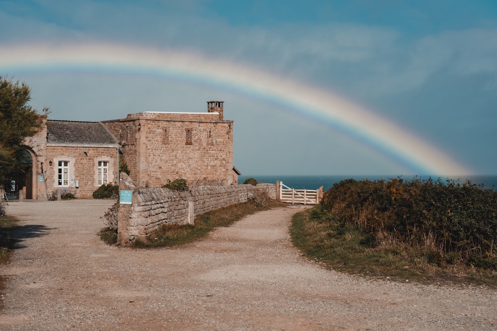 a rainbow is in the sky over a house