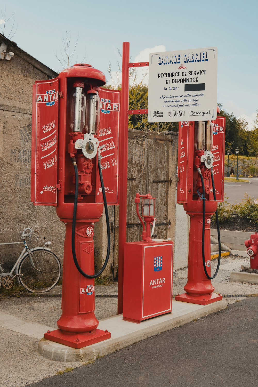 deux pompes à essence rouges assises l’une à côté de l’autre