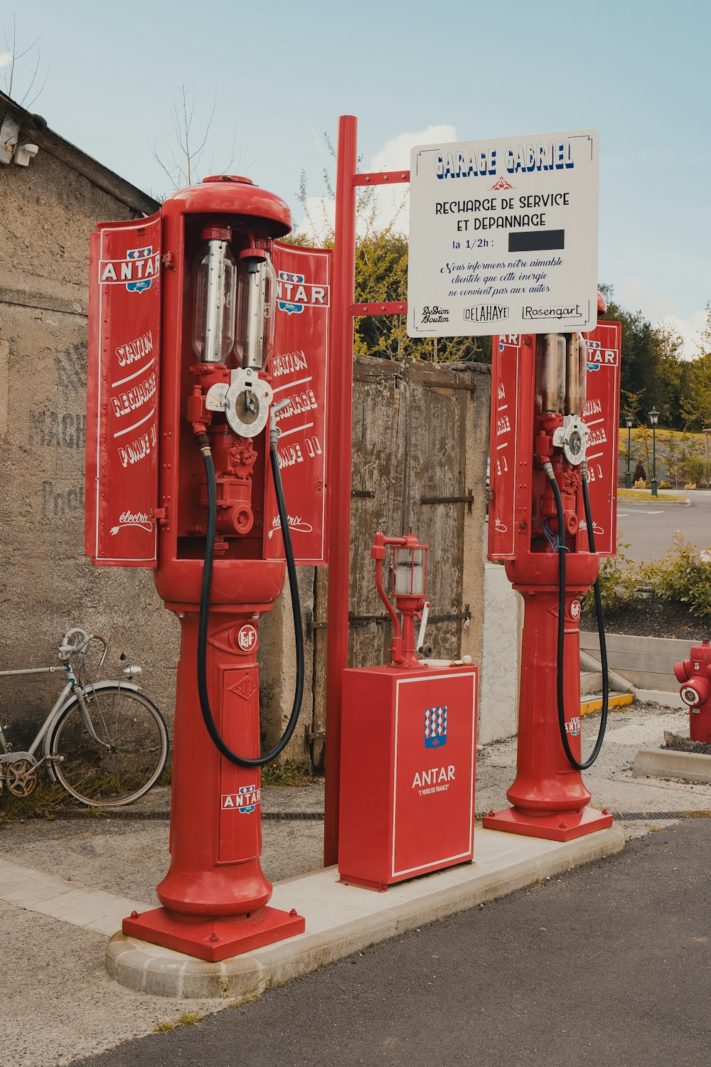 two red gas pumps sitting next to each other