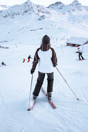 A woman skiing down a snowy mountain wearing a sleek, form-fitting base layer.