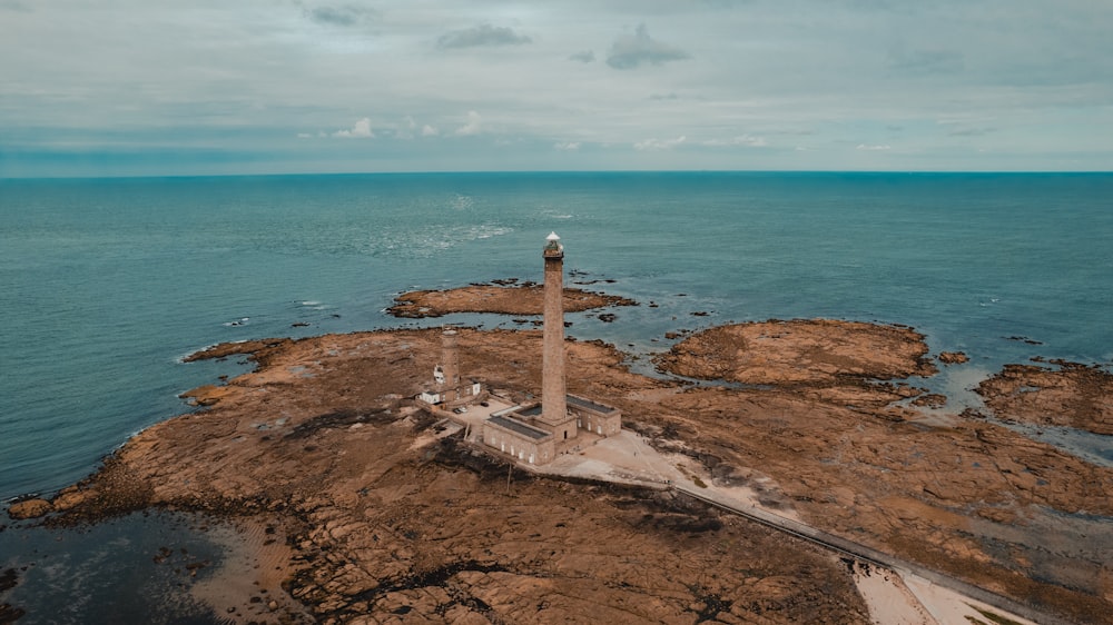 an aerial view of a lighthouse in the middle of the ocean