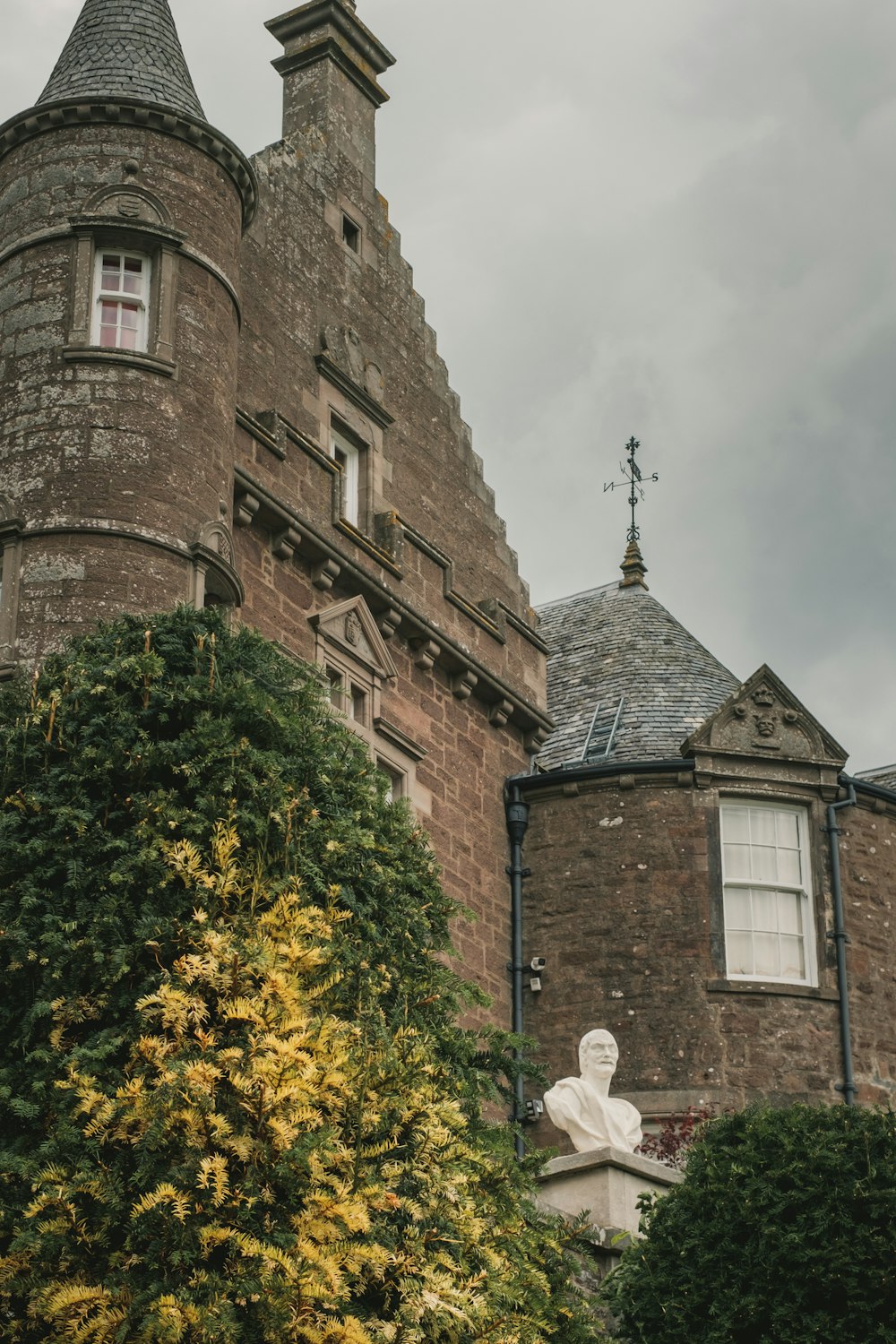 a tall brick building with a statue in front of it