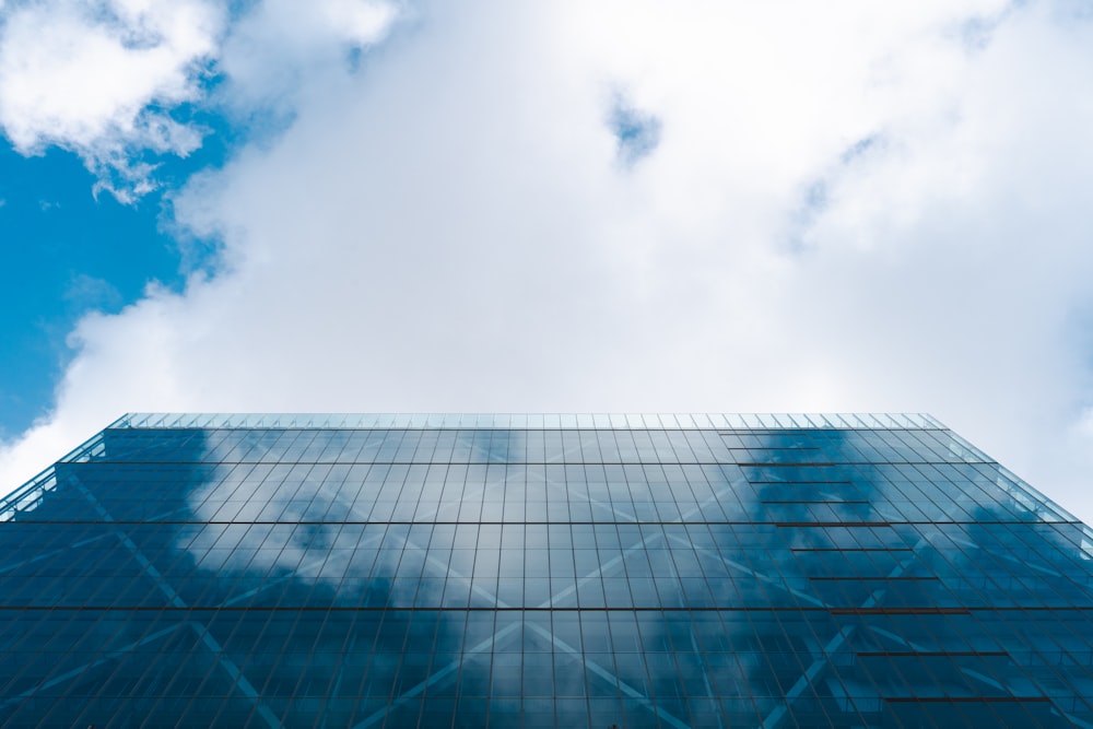 a tall glass building with a sky background