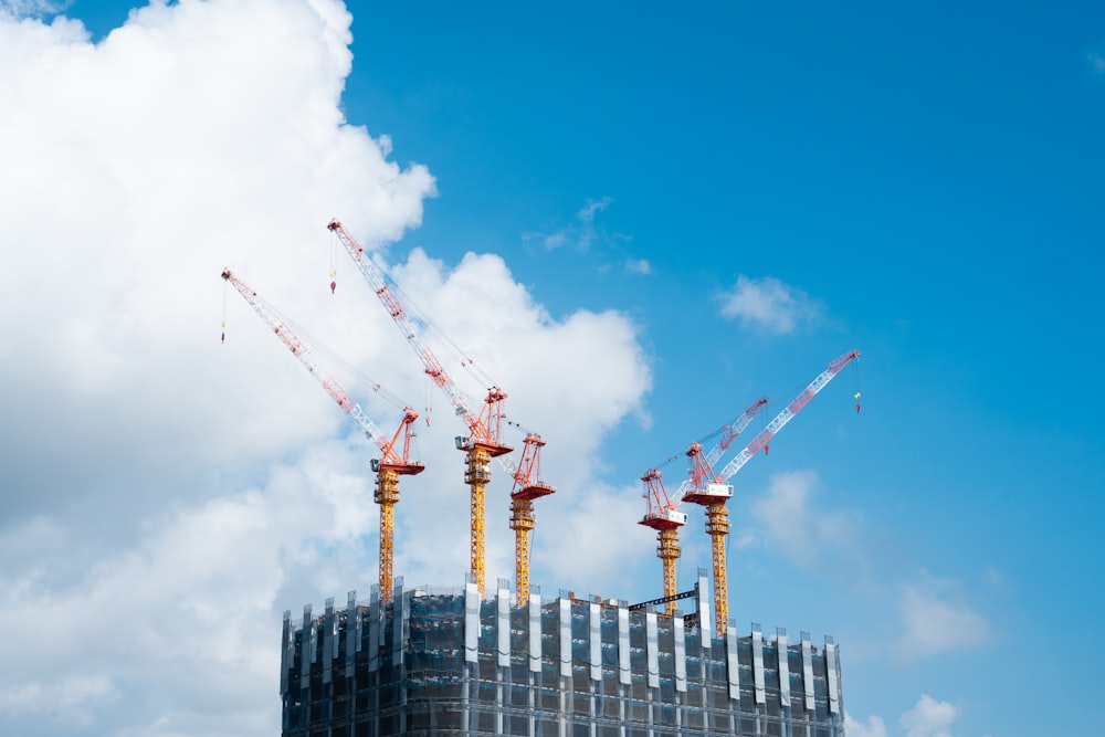 a group of cranes that are on top of a building