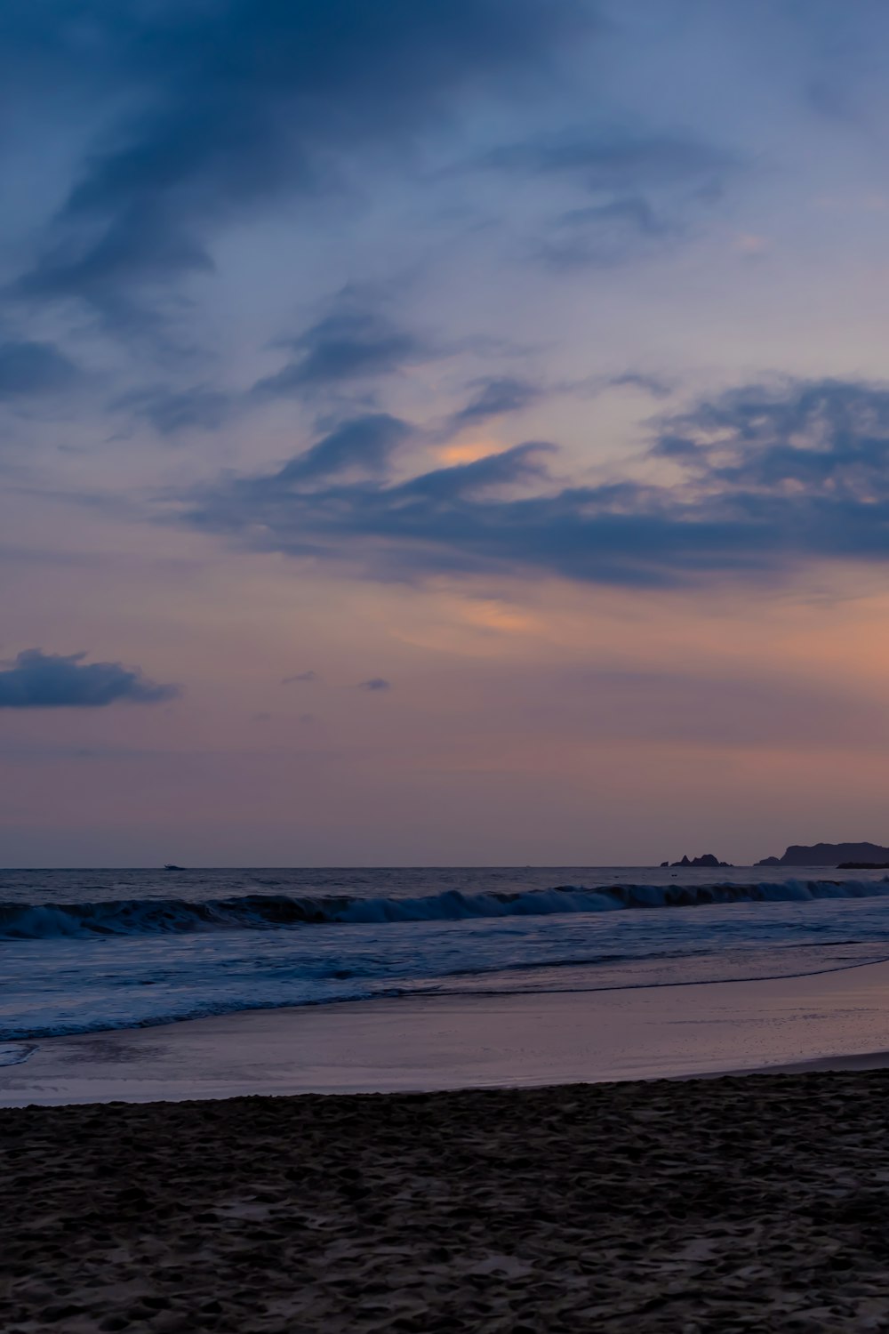 a person walking on a beach with a surfboard