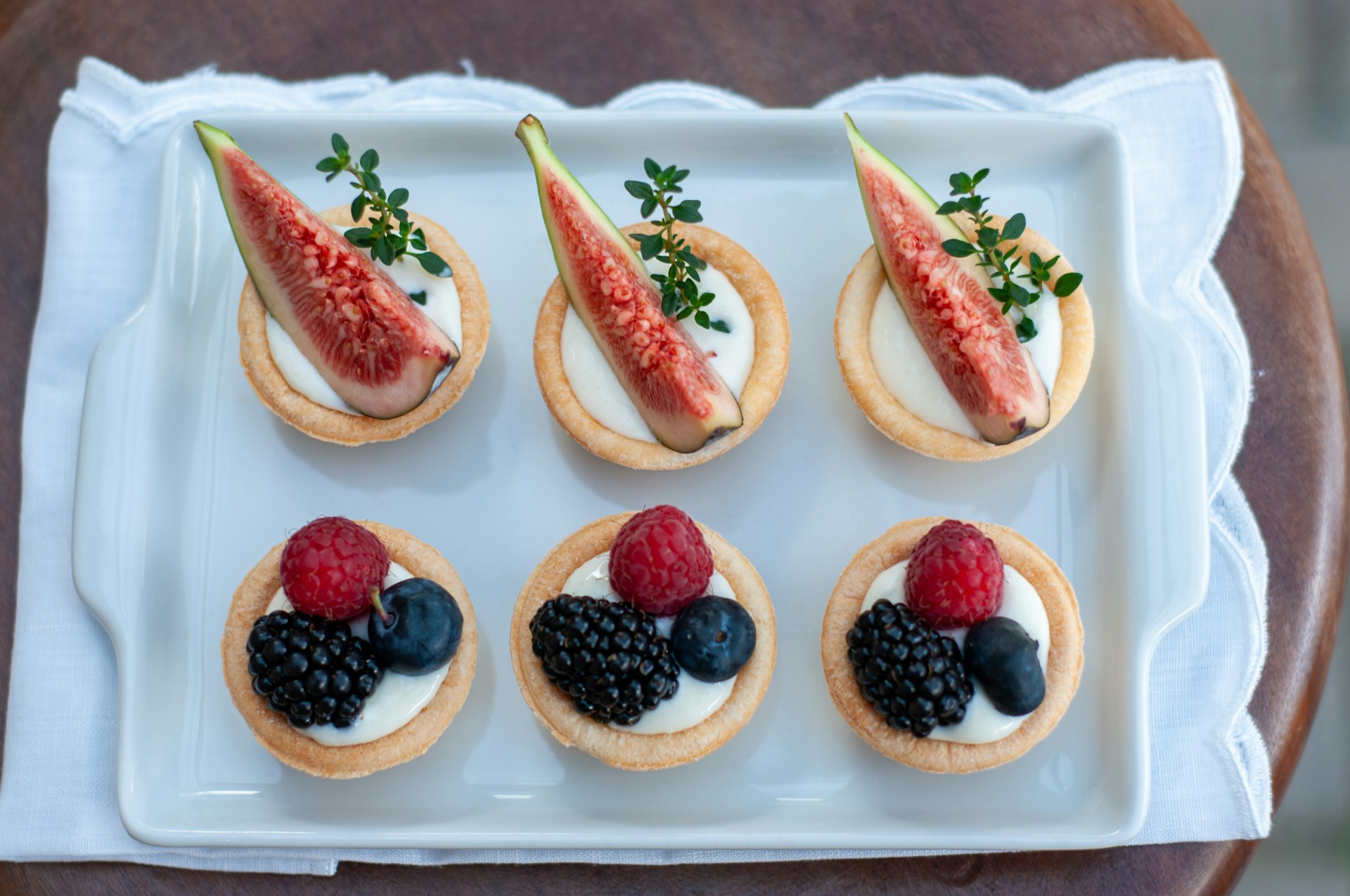 a white plate topped with mini desserts covered in fruit