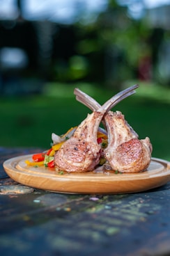 a wooden plate topped with meat on top of a wooden table